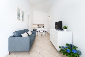 a living room with a blue couch and a television at Residence con piscina Piricone in Orosei