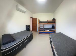 a bedroom with two beds and a bunk bed at Faith Home 1 in Arraial do Cabo +47 photos