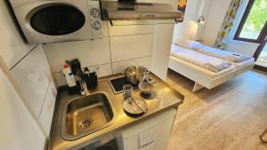 a small kitchen with a sink and a microwave at Aparthotel Marion Weber in Bremen