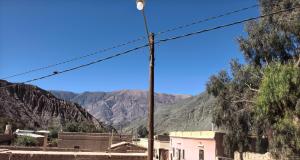 a street light with mountains in the background at ElPoro in Purmamarca +1 photo