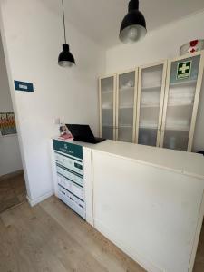un ufficio con un bancone bianco con un computer portatile sopra di 70's Hostel a Ericeira Altre 20 foto