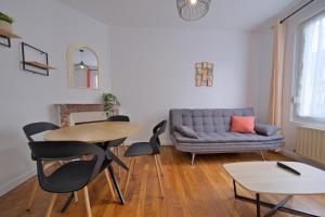 a living room with a couch and a table and chairs at Margherita in Reims