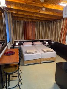 a bedroom with two beds and a table and a desk at Shefer Guesthouse in Eilat