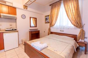 a small bedroom with a bed and a window at VILLA Vasilios EXARHOS in Paralia Katerinis