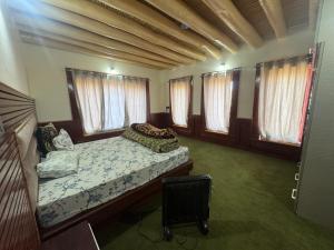 a bedroom with a bed in a room with windows at Cho Farm House in Leh +11 photos