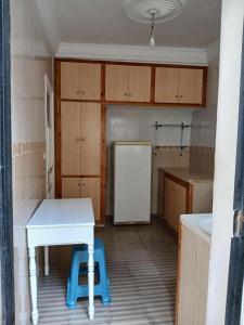 a kitchen with a white table and a refrigerator at Appartement Détente Hammamet in Hammamet