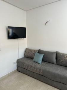 a couch in a living room with a flat screen tv at Appartement avec piscine, résidence assadaka in Saïdia