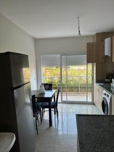 a kitchen with a table and a dining room at Appartement avec piscine, résidence assadaka in Saïdia