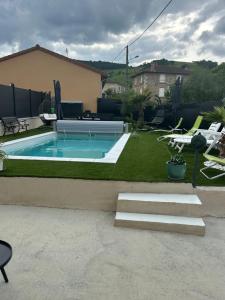 a backyard with a swimming pool and a yard with chairs at Chez TIKA in Saint-Lager