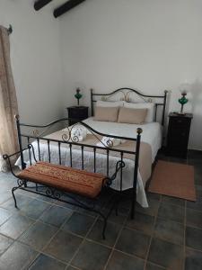 a bedroom with a bed with a bench next to it at Monte Santiago in Fronteira +14 photos
