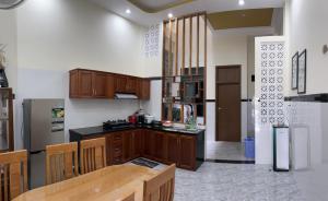 a kitchen with wooden cabinets and a table and a refrigerator at TRI'S Homestay in Quy Nhon