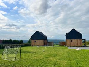 two barns in a field with a goal at Domki Baby Jagi in Krajno Pierwsze