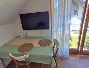 a room with a table with two chairs and a large window at Mountain view in Medvode