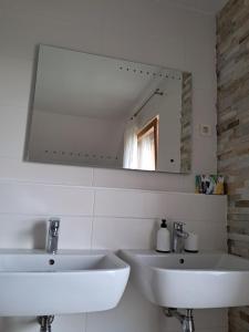 a white bathroom with two sinks and a mirror at Mountain view in Medvode