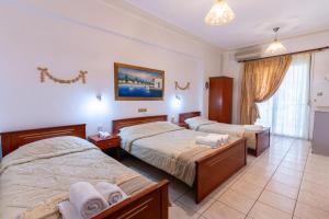 a hotel room with two beds and a bathroom at VILLA Vasilios EXARHOS in Paralia Katerinis