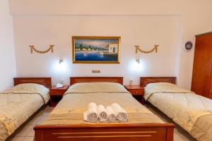 a room with three beds with towels on them at VILLA Vasilios EXARHOS in Paralia Katerinis