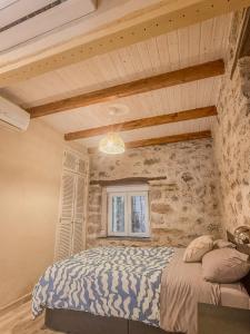 a bedroom with a bed and a stone wall at Apartamento Las Medulas in Covas