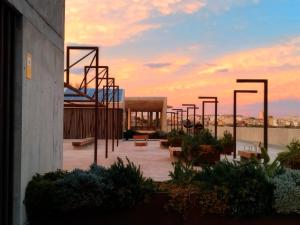 a building with a sunset in the background with benches at Valencia Room in Cuart de Poblet