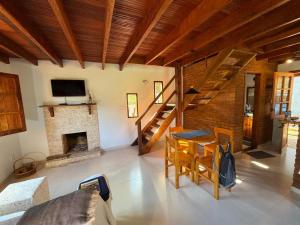 a living room with a table and a fireplace at Chalé Terra Nova in Itamonte