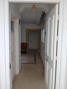 a hallway with white doors and a room with a couch at Appartement Détente Hammamet in Hammamet