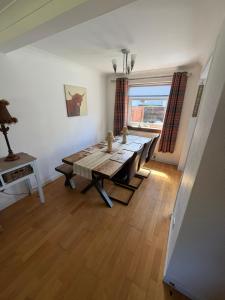 a dining room with a wooden table and a large window at Fab-u-Luss in Luss