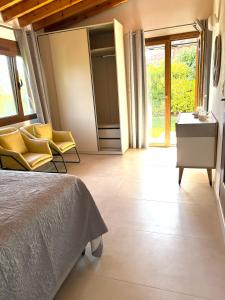 a bedroom with a bed and yellow chairs in it at BAREFOOT COTTAGE in Skiathos