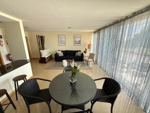 a living room with a table and chairs at Sol Poente Praia Apartment in Apúlia