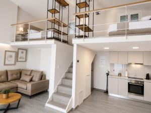 a loft apartment with a staircase and a living room at Thalasson Beach House in Koroni