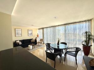 a living room with a table and chairs and a couch at Sol Poente Praia Apartment in Apúlia