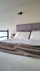 a large bed with white sheets and a headboard at Dris Loft in Nikiana