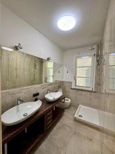 a bathroom with two sinks and a toilet at Luxury Villa Cenaia in Cenaia Vecchia +13 photos
