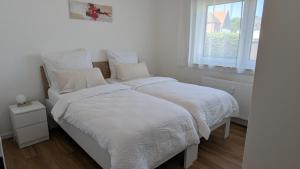 two beds in a white bedroom with a window at Rudolph Apartments Kleve in Kleve