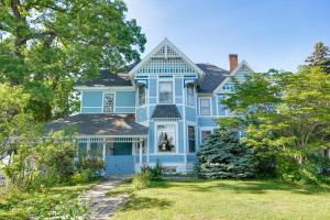 a blue house with a yard with trees at White Rose Inns & Motel in Wisconsin Dells