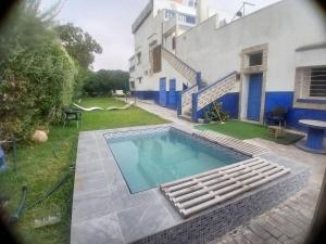 a swimming pool in front of a house at Maison bleu in Oualidia