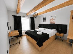 a bedroom with a large bed and a desk and a table at Apartament Rynek Szmaragd in Szamotuły