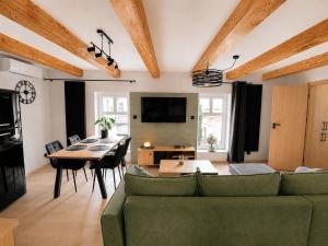 a living room with a green couch and a table at Apartament Rynek Szmaragd in Szamotuły