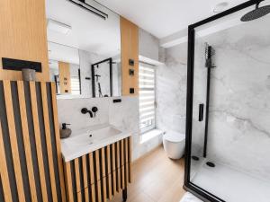 a bathroom with a white sink and a shower at Apartament Rynek Szmaragd in Szamotuły +5 photos