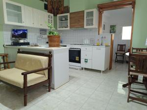a kitchen with white appliances and a table and a chair at Forest Retreat Near the Sea Kouvaras in Kouvarás