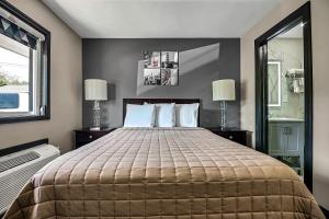 a bedroom with a large bed with two lamps at Best Way Inn in Middlefield