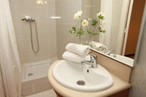 een badkamer met een wastafel en een vaas met bloemen bij Pension La Calma in Barcelona