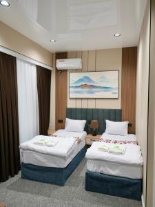 a hotel room with two beds in a room at Milliy Hotel - Namangan city in Namangan +11 photos