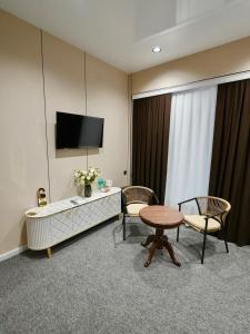 a hotel room with a table and chairs and a tv at Milliy Hotel - Namangan city in Namangan