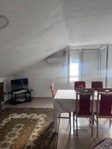 a dining room with a table and chairs and a television at Beara in Lepetani
