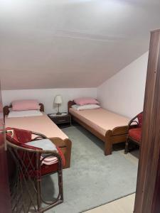 a room with two beds and a chair in it at Beara in Lepetani