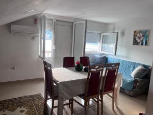 a dining room with a table and chairs and a couch at Beara in Lepetani