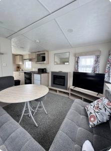 a living room with a table and a couch at Brand New Caravan in Selsey