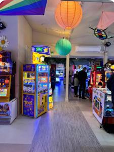 a room with arcade machines and people playing a video game at Brand New Caravan in Selsey