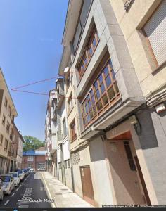 a building on the side of a street with cars parked at Duplex Arriondas in Arriondas