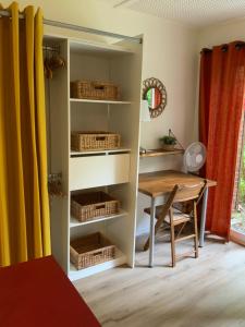 a dining room with a table and a book shelf at Studio Tennis Riviere in Annecy