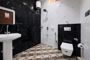 a bathroom with a toilet and a sink and a shower at Live Free Hostel Dehradun in Dehradun +28 photos